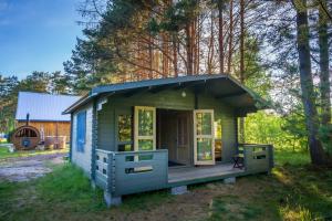 UuluMetsaääre Accommodation的一个小的绿色房子,设有门廊