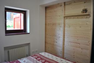 阿贝托内La casetta di Viola的卧室配有木墙,毗邻一张床