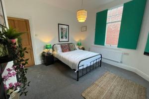 切斯特BOUTIQUE CITY CENTRE APARTMENT WITH PARKING的一间卧室设有一张床和绿色的墙壁