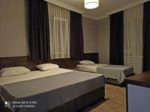 阿拉尼亚Merve Apart Hotel的酒店客房设有两张床和窗户。