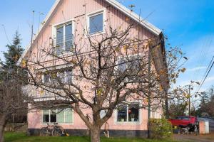 斯德哥尔摩Pink House Room#1 Stockholm的前面有一棵树的粉红色房子
