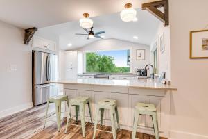富丽海滩Lake Folly的厨房配有白色橱柜和绿色凳子