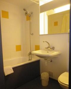 沃雷普沃雷普艾米斯酒店的浴室配有盥洗盆、卫生间和浴缸。