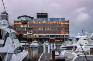 奥克兰Park Hyatt Auckland的码头前停泊着船只的酒店