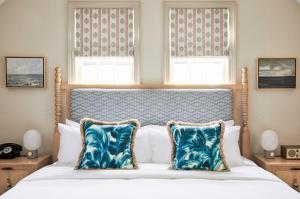 楠塔基特Faraway Nantucket的一间卧室配有一张带蓝色枕头的大床
