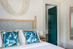 楠塔基特Faraway Nantucket的一间卧室配有一张带蓝色枕头和镜子的床