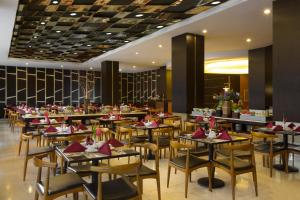 马格朗马格朗阿特里亚酒店的用餐室配有桌椅和红色餐巾