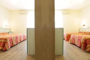 利尼亚诺萨比亚多罗Hotel San Marco的配有两张床的酒店客房中的两张床