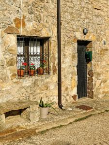 CidonesCasa independiente y completa con una habitación "Venta de Cidones"的一座石头建筑,有两扇窗户和盆栽植物