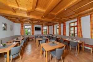 魏勒格Haus Weyregg - Pension的餐厅设有木制天花板和桌椅