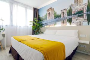 马德里Hotel BESTPRICE Alcalá的一间卧室配有一张大床,床上有黄色的毯子