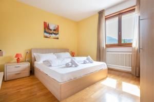 加尔达湖滨Appartamento Le Vele的一间卧室设有一张大床和一个窗户。
