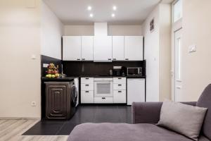 布达佩斯Prime star Deak ter Modern Luxury Apartments Budapest的一间厨房,内设白色橱柜和沙发