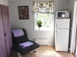 StråvallaStråvalla Hulegården的厨房配有椅子、冰箱和窗户。