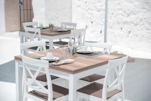奥斯图尼Masseria Donna Nina的白色的餐桌、白色的椅子和木桌