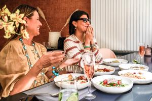 雅典The Marblous Athens的两个坐在餐桌上吃食物的女人