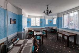 RodwellThe Old Castle Hotel的一间拥有蓝色墙壁和桌椅的用餐室
