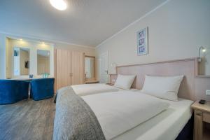 帕彭堡FF&E Hotel Engeln的一间带白色大床的卧室和一间浴室