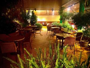 罗萨斯Hostal ROM Familiar的餐厅内带桌椅的庭院