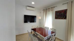 科尼尔-德拉弗龙特拉Villa Almadraba的一间带桌椅和电视的用餐室