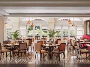金边莱佛士酒店的用餐室设有桌椅和窗户。