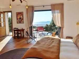普罗普里亚诺U Castellu Chambres d'hôtes & Location villa et appartements vue mer的一间卧室设有一张床和一个美景阳台