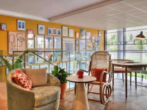 尼斯尼斯机场诺富特套房酒店的一间配有沙发和桌子的房间和一堵画墙