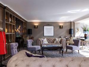 温莎Castle Hotel Windsor的客厅配有沙发和桌子