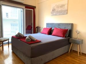雅典HIGH QUALITY 110qm 2BR at Simos-Lux-Apartment的一间卧室配有一张带红色枕头的大床
