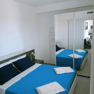 圣玛丽亚巴格诺Residence Valentina - Apartment Laura int 9的一间卧室配有两张蓝色的床和镜子