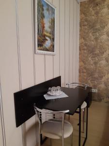 顿河畔罗斯托夫Rostov Hotel的一张带两把椅子的黑桌和墙上的照片