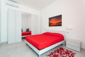 卡布拉斯CASA L'ANGOLO FIORITO的白色卧室配有红色的床和红色地毯