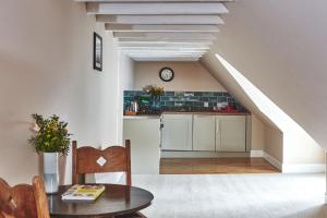 因弗雷里因弗雷里黑刺莓旅馆的厨房配有白色橱柜、桌子和楼梯。