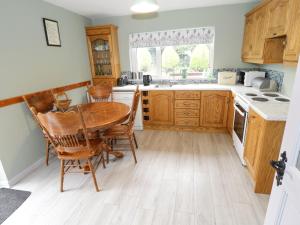 卡斯尔巴Sean Bhaile的厨房配有木制橱柜和木桌及椅子