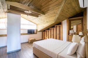 阿奇亚卡XOX Apart Hotel的一间卧室设有一张带木制天花板的大床