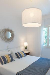 普拉提伊亚洛斯西弗诺斯NEFELI'S GUESTHOUSE IN PLATYS GIALOS SIFNOS的卧室配有白色的床和镜子