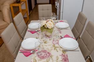拉布Apartments Šćerbe 3103的桌子上放有盘子和玻璃杯,花朵