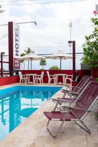 瓜鲁雅米拉马雷普拉亚酒店的一个带桌椅和遮阳伞的游泳池