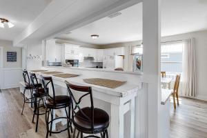 多芬岛Malibu Beach House的厨房配有带凳子的大柜台。
