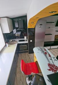 茹里洛夫卡Apartament Mara的厨房配有冲浪板、柜台和红色椅子