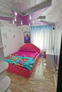 茹里洛夫卡Apartament Mara的一间设有红色床的卧室,位于一间拥有紫色天花板的房间