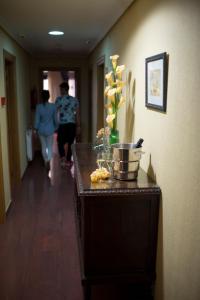 埃尔希耶戈埃西耶格别墅酒店的一位女士在走廊上走下,在走廊上摆着鲜花