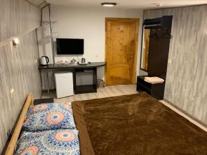 特维尔Sitara Hostel的一间卧室配有一张床、一张书桌和一台电视