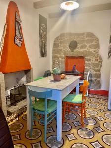努奥罗B&B Pascal House Nuoro_IUN E5016的石制壁炉的客房内的桌椅
