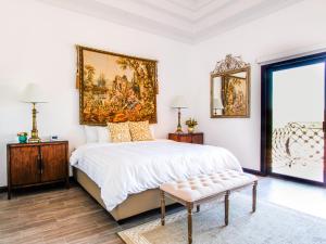 埃莫西约Hotel Boutique Villa Toscana的卧室配有一张大床,墙上挂有绘画作品