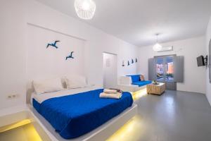 梅加洛克里Majestic Sky Luxury Suites的白色卧室配有蓝色的床和沙发