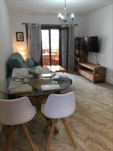 奥里韦拉海滩Cabo Roig Bellavista 26的客厅配有桌子和两把白色椅子