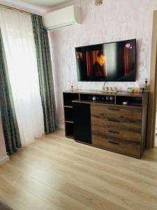 雅西Dina Lux Iasi Apartment的客厅配有梳妆台上的平面电视