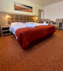 托斯恩斯Strand Hotel Nordsee, Hotel Deichläufer的一间卧室配有一张带红色毯子的大床