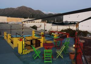 卡皮亚德尔德尔蒙特Malecon en calle Techada Hostel的屋顶上几张五颜六色的椅子和桌子
